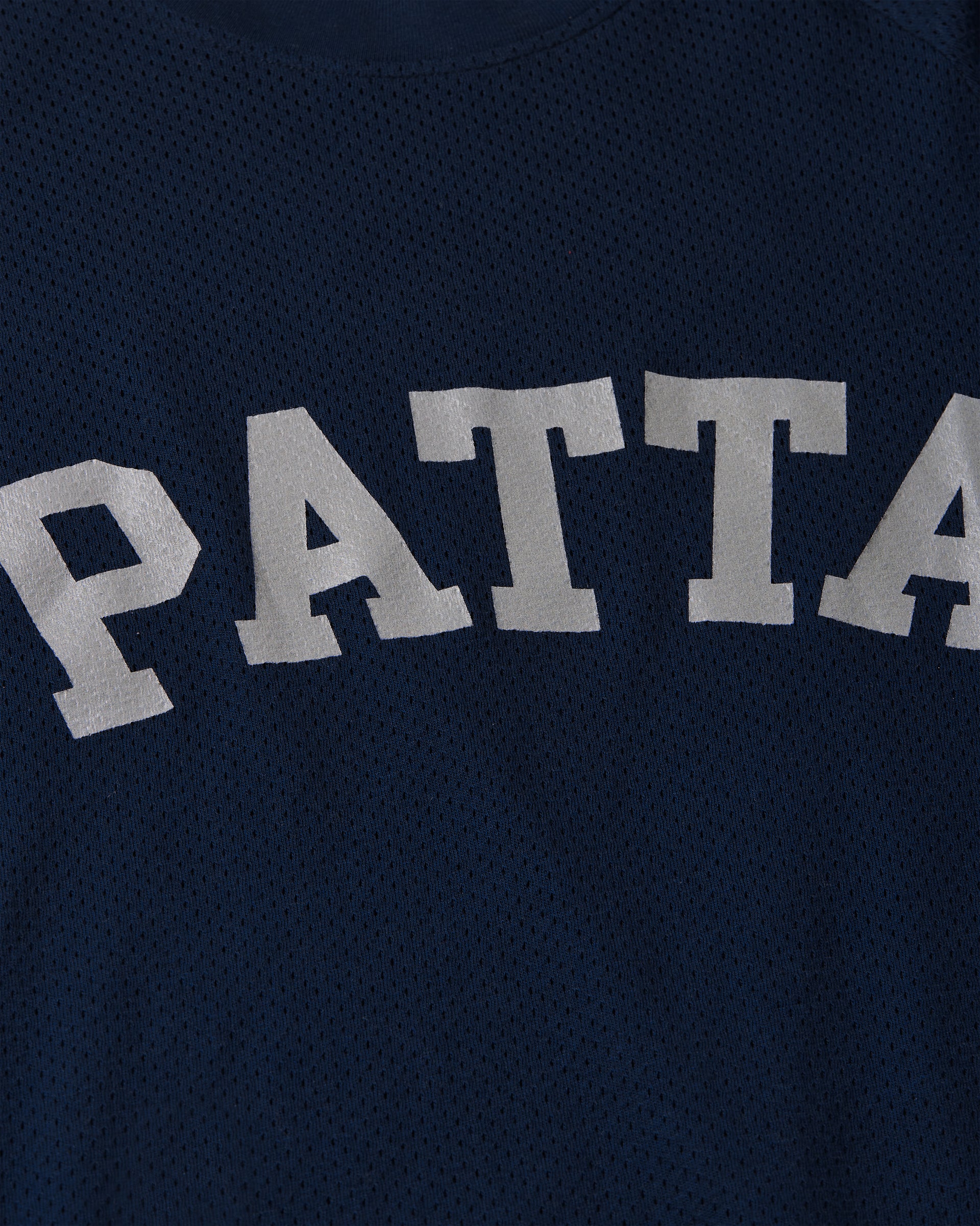 close up detail shot of the applied branding on the mesh arc longsleeve in navy