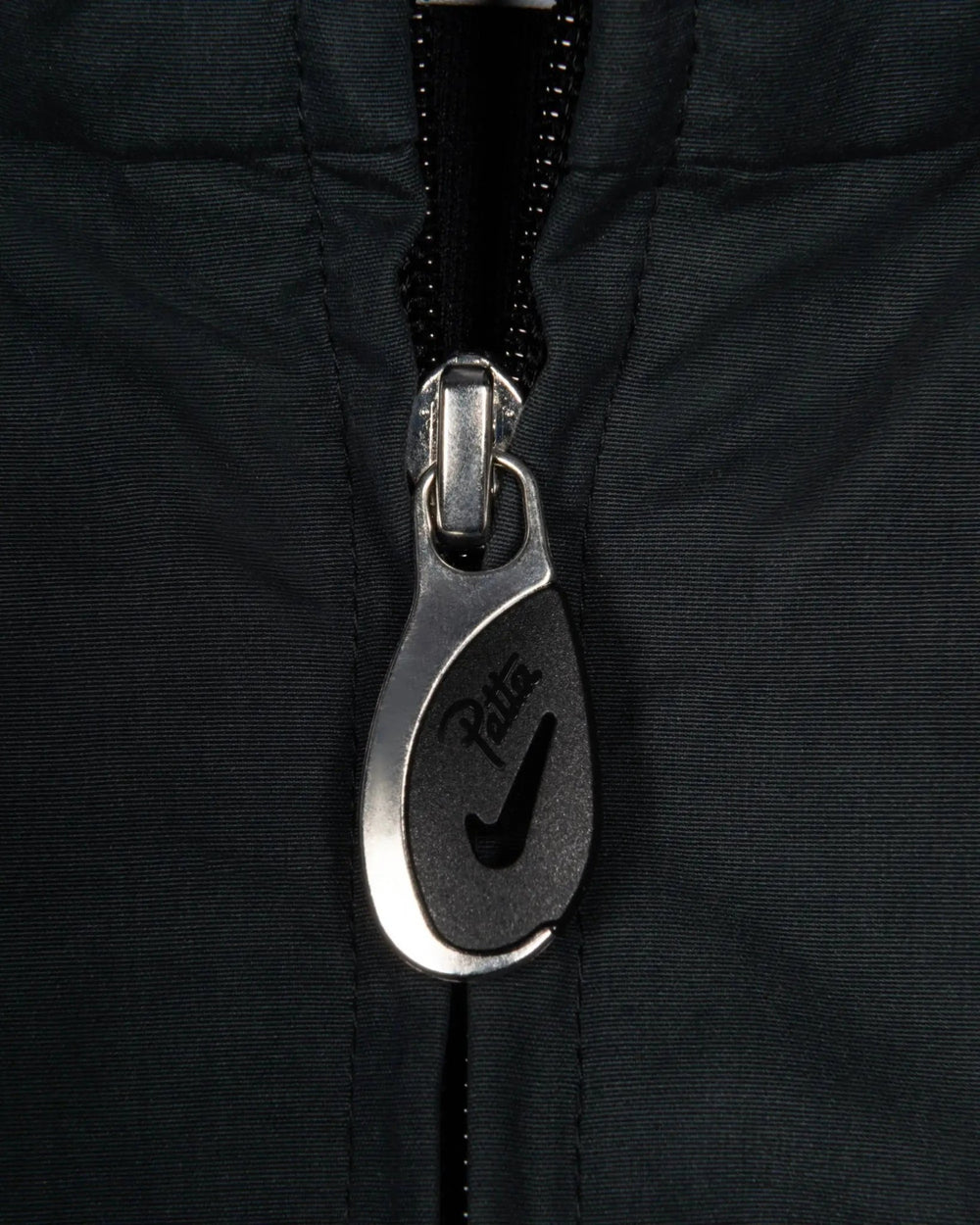 Custom Patta x Nike zipper puller detail on the black NRG Track Jacket.