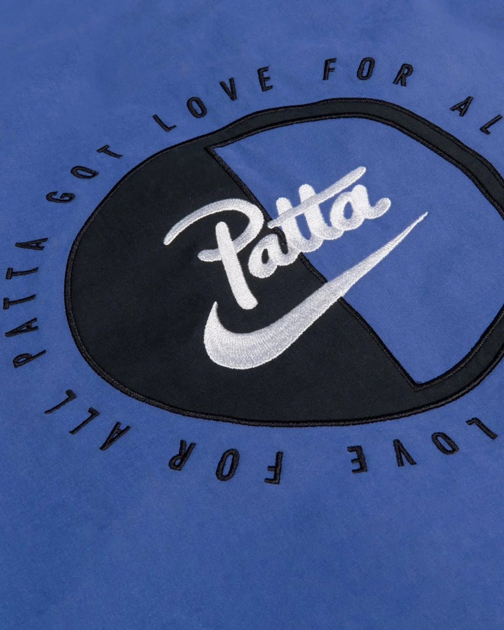 Embroidered Patta x Nike logo patch detail on the sapphire blue NRG Track Jacket.